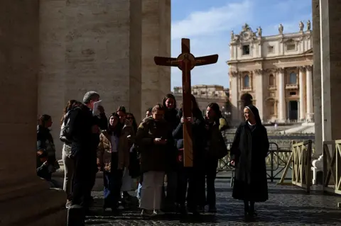 Reuters People carry a cross in St. Peter's Square, at the Vatican, on 26 February 2025