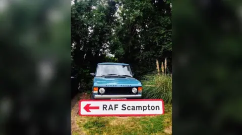 Steve Jollands The RAF Scampton sign with a red arrow pointing left in front of a blue Range Rover to show how big it is