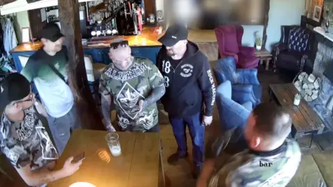 Men stood around in a pub