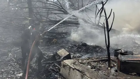Firefighters tackle debris after plane crash