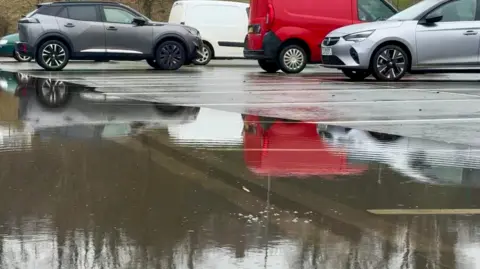 Surface water surrounds vehicles in a car park in Haverfordwest, Pembrokeshire, on Wednesday, courtesy of BBC Weather Watcher Rosierees