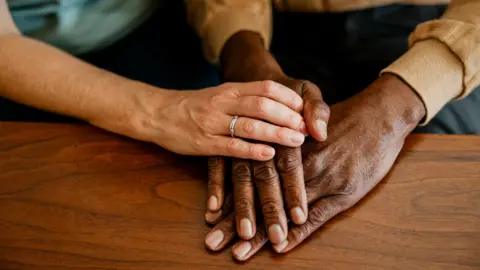 Getty Images A close up of two adults holding hands