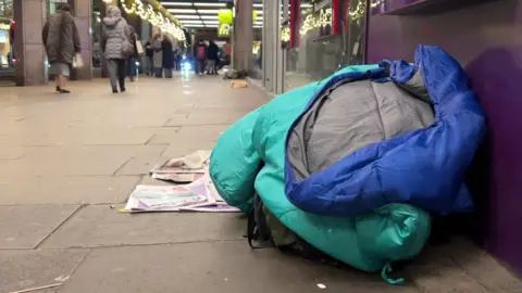 An empty sleeping bag on the pavement in Victoria, London.