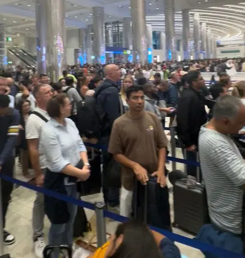 Mic Cassidy People queuing at check in desks at Dubai Airport