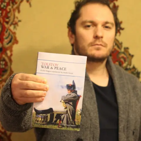 Ander Louis Um homem mostra para a câmera um exemplar de Guerra e Paz, de Leo Tolstoy.