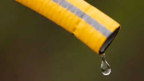 Generic image of a water droplet coming from a yellow hose