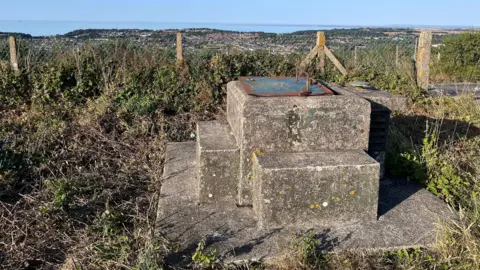 Some concrete slabs in front of a fence.