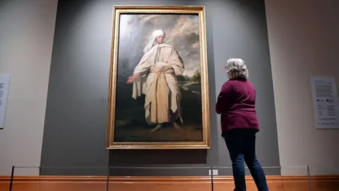 Portrait of Mai by Sir Joshua Reynolds in Cartwright Hall. A woman stands in front of the painting, admiring it.