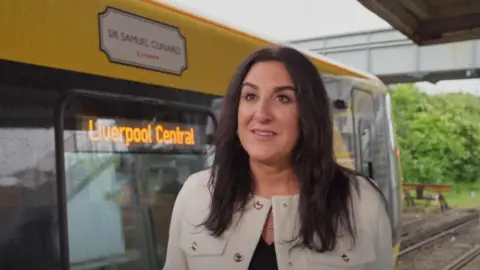 LCRCA Katie McAlister, President of Cunard, stood next to Merseyrail train
