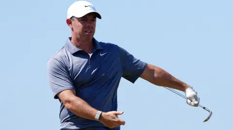 PA Rory McIlroy swings a golf club.