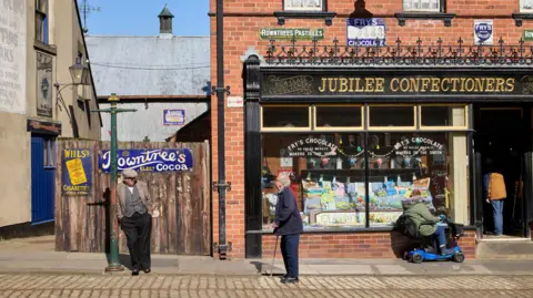 David Levene A street scene at Beamish open-air museum in Country Durham, showing men standing outside a confectioners