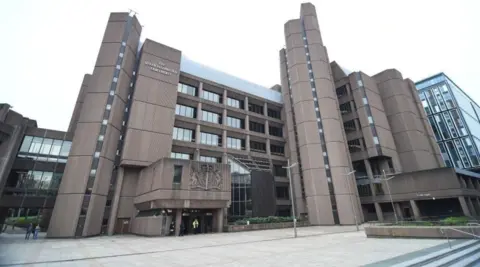 PA Media The exterior of Liverpool Crown Court including the main entrance with a large Royal crest above.