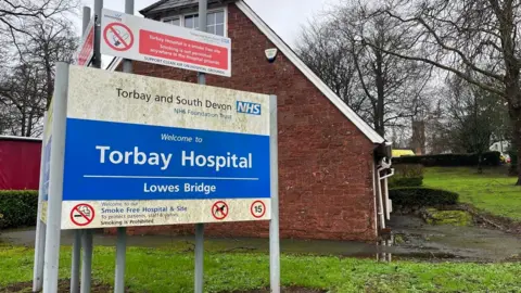 The blue and white sign for the Lowes Bridge entrance to Torbay Hospital