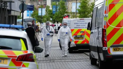 PA Forensic examiners in protective clothing walking in the street where the baby was found