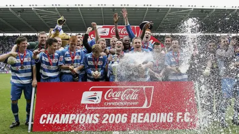 Getty Images Reading players celebrating and spraying champagne after being presented with the Championship trophy at the then Madejski Stadium in Reading.