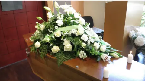 Getty Images A coffin with a wreath on top 