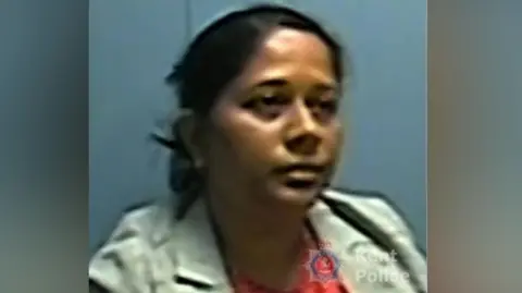 Danuska Pullia pictured during her interview with Kent Police. She has her hair tied up in this picture, and is wearing a grey jacket and red top. 