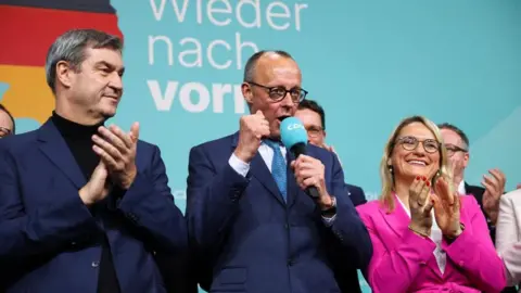 Image shows German conservative candidate for chancellor and Christian Democratic Union (CDU) party leader Friedrich Merz on stage next to Bavarian state premier and leader of the Christian Social Union (CSU) Markus Soeder, after the exit poll results are announced for the 2025 general election, in Berlin, Germany, on 23 February2025
