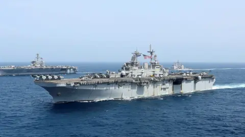 Reuters Aircraft carrier USS Abraham Lincoln is seen in the open ocean, with a US flag clearly visible.