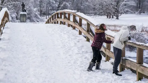 People throw snowballs on a snow-covered bridge in Massachusetts on 19 January