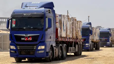 Gaza Humanitarian Foundation/Handout via Reuters Handout photo from the Gaza Humanitarian Foundation showing lorries carrying humanitarian aid in Gaza (26 May 2025)