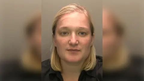 Lincolnshire Police Police custody photograph of Melissa Abolina with shoulder-length blond hair wearing a black shirt