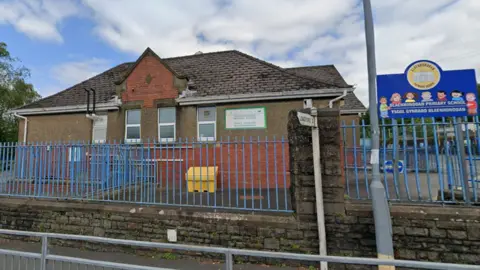 Bleanhoddan Primary School seen from the outside. It is a brick building with railings around the perimeter 