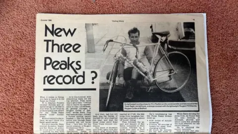 The photo shows an article from Cycling World, dated October 1980. The headline reads: "New Three Peaks Record?" Next to the headline is an image of a much younger Steve Poulton, crouching down behind his bike. 