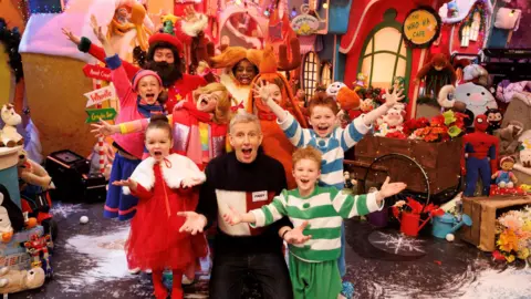 Andres Poveda Photography Paddy Kielty surrounded by children dressed up as characters from The Grinch 