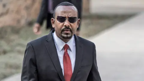 Ethiopian Prime Minister Abiy Ahmed in grey suit, white shirt and red tie arrives to address a parliament session in Addis Ababa, Ethiopia - 2023.