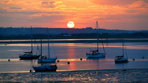 WEDNESDAY - A sunrise over water at Gosport, with yachts in the foreground