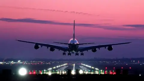 An Emirates Airbus A380 lands during sunrise at London Gatwick Airport.