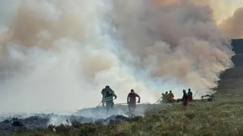 A group of firefighters tackling a large-scale wildfire in the Cairngorms.
