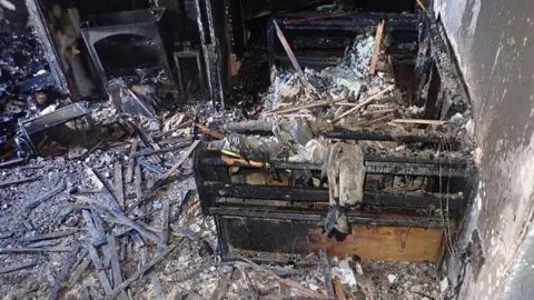 London Fire Brigade A burnt out room, with black debris.