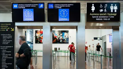 Getty Images Passport control for international flights is seen at Venice Airport, with digital screens displaying information about the European Union's Entry/Exit System (EES).