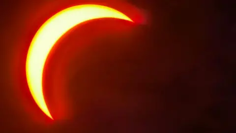 Torbay Adventurer A red crescent Sun as seen in the skies above Churston Ferrers, Torbay.