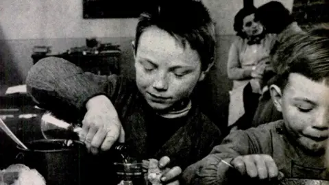A child pours wine in 1954