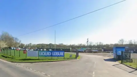 Google A Google Streetview of a road heading to a car park with a Liquid Leisure sign on a blue hoarding attached to the fence alongside.