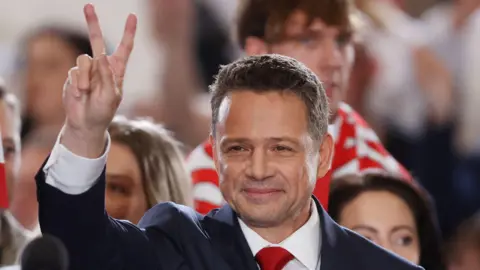 Reuters Warsaw Mayor Rafal Trzaskowski, the presidential candidate of the Civic Coalition reacts to the exit poll for the first round of Poland's presidential election, in Sandomierz, Poland, May 18, 2025.
