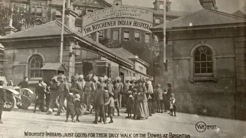 Royal Pavilion & Museums A black and white archive photograph shows Indian soldiers and civilians gathered outside the Kitchener Indian Hospital in Brighton.