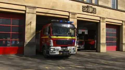 An Avon Fire and Rescue fire engine emerging from a station. 