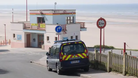 An emergency vehicle which says Gendarmerie on the back, parked up at the beach