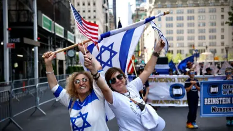 Two women wave Israeli and US flags at Israel Day Parade in NYC