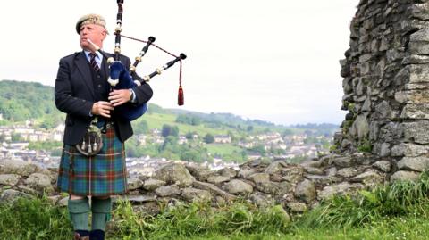 Richard Cowie playing bagpipes in Kendal