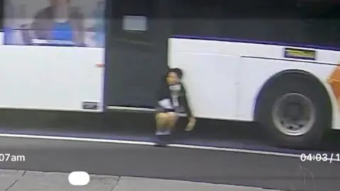 CCTV captures boy dangling off side of a bus