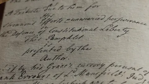 Goodwood Collection Handwriting on paper which reads "A tribute due to him for his strenuous efforts and unwearied perseverance in the defence of constitutional liberty. This pamphlet is presented by the author."