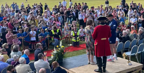 A large crowd at an outdoor awards ceremony. 