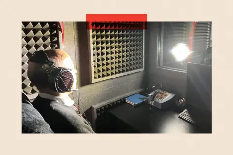 Pallab sitting in the 'Dreamachine' soundproofed booth, his eyes closed and wearing headphones, with a strobe light aimed at him