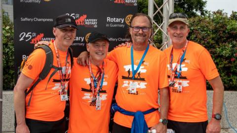 Four men in orange t-shirts after completing the Saffery walk