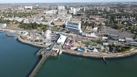 Paul Davis/Historic England Aerial image of Southend pier, showing adjoining amusement park and the city of Southend